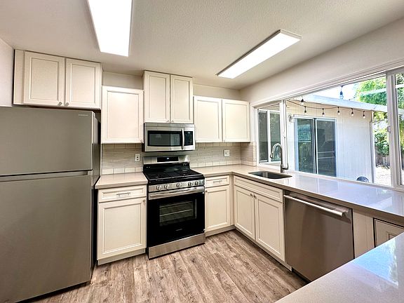 Bright eat-in kitchen with breakfast bar, stainless appliances and lots of sunlight.