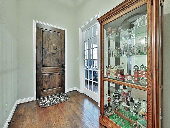 Warm entryway with mahogany front door containing a window latch to allow you to see outside. The room to the left can either be