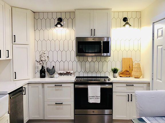 Plenty of white shaker cabinets and solid surface countertops. White farmhouse sink and all stainless steel appliances. Luxury vinyl flooring throughout.