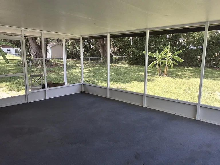 Large screened porch overlooks shaded yard