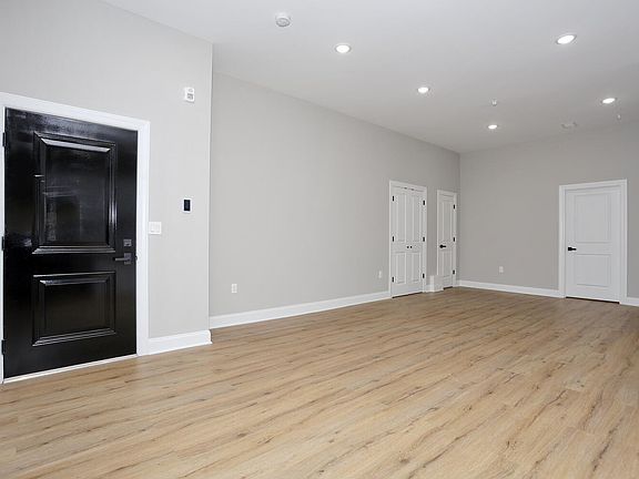 Large living room & dining room with view of pantry and coat closet.