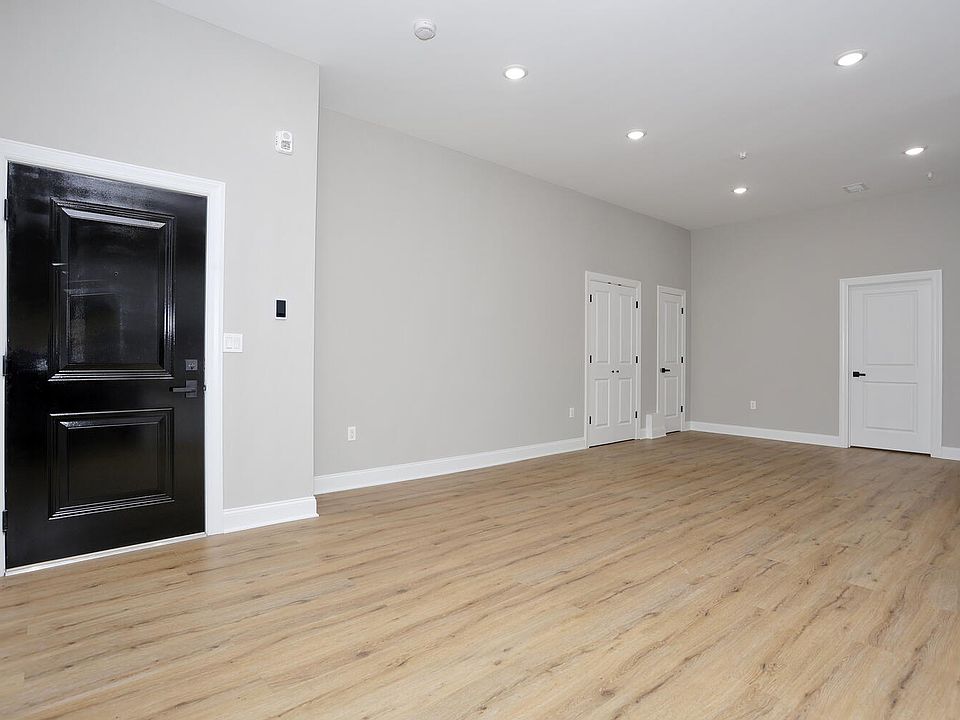 Large living room & dining room with view of pantry and coat closet.