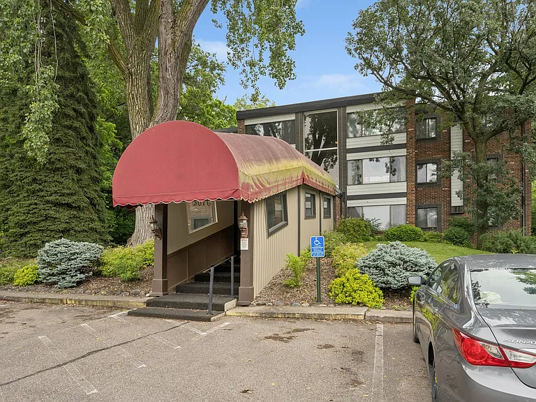 Front exterior with covered entrance, Lexington Avenue is behind us and the garages are to the right and down a slope from the entry.