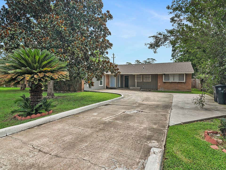 This charming brick home sits on a beautifully landscaped lot with mature trees and lush greenery.