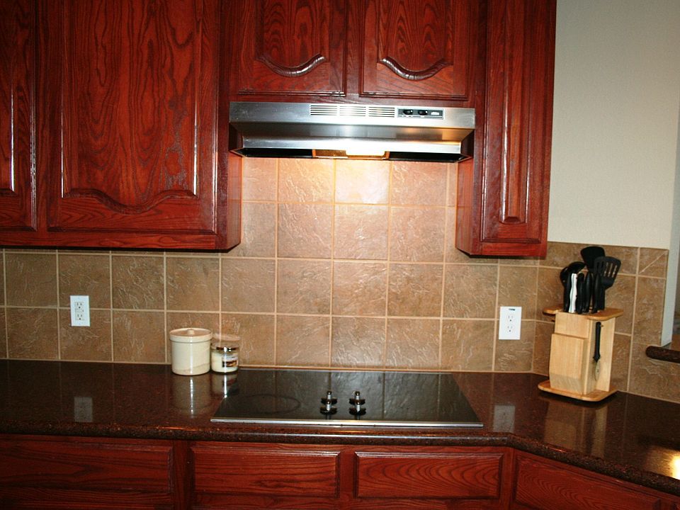 Dark custom cabinets, tile backsplash & smooth cooktop