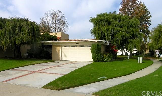 Single story patio home surrounded by greenbelt and trees.