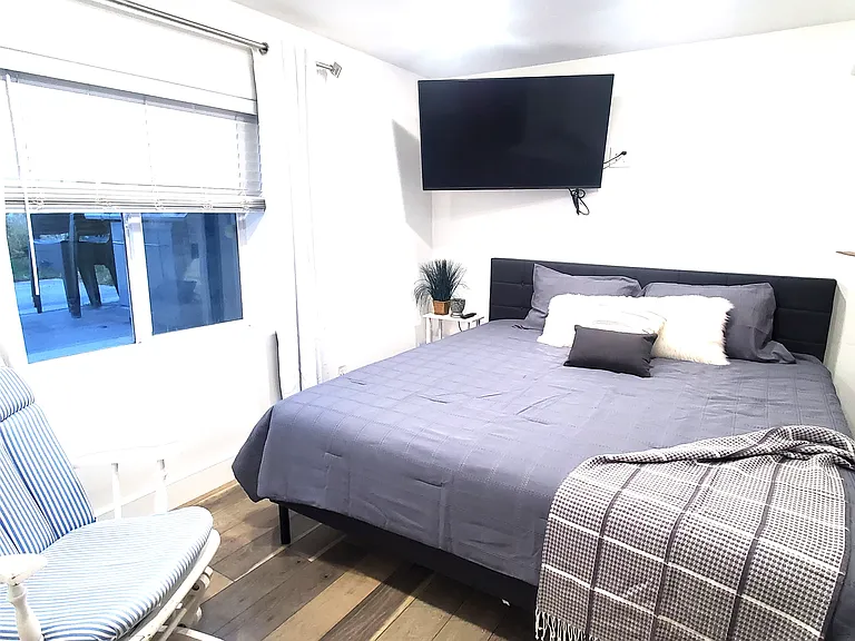 A different view of the master bedroom, showing its capacity for a King-sized bed. Equipped with blackout curtains to ensure a deep, restful sleep any time of day. (Furniture not included).
