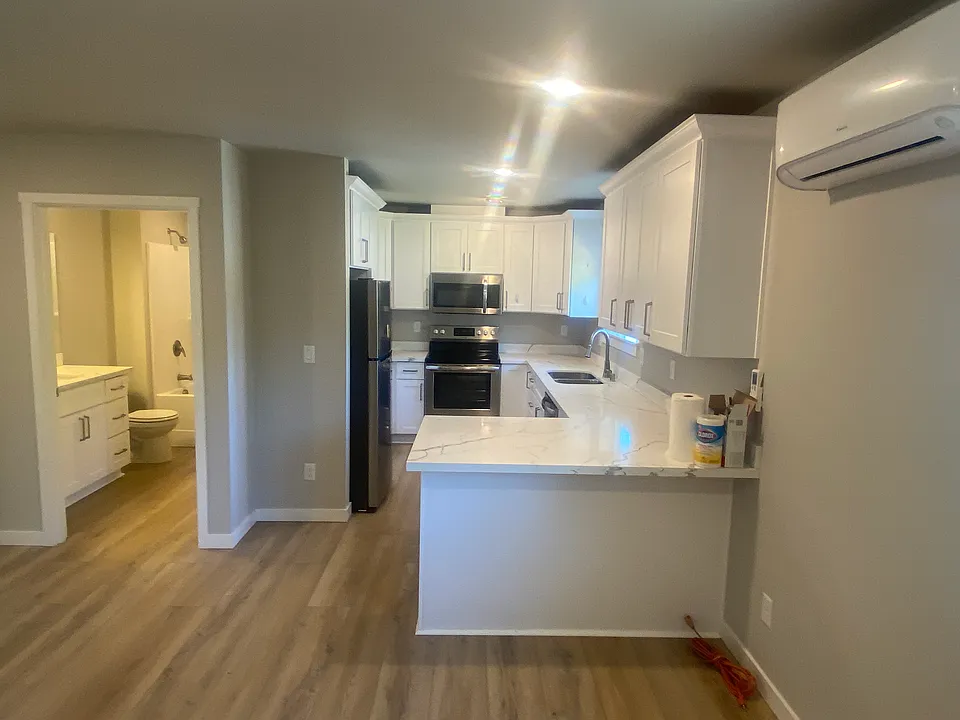 Beautiful kitchen complete with quartz countertops and soft close doors. Several lazy Susan's built in to cabinets to give additional storage. Easy clean faux wood floors throughout. Perfect lighting highlights this space.