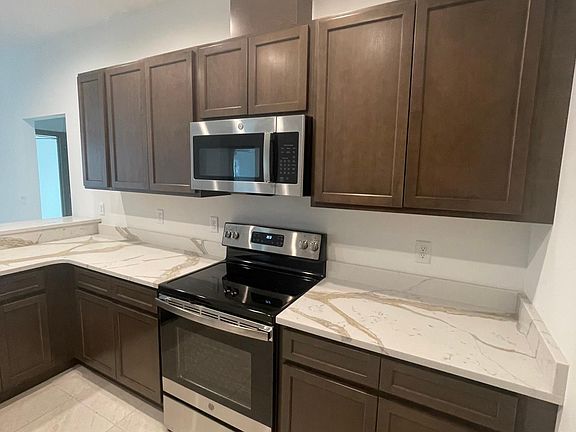 New Built , Large Open Concept Kitchen with Calacatta Countertops, Sleek and Stylish design. Lots of Cabinets, Pantry Cabinet, Walk-in Pantry Closet, Flat Top Stove , Built-in Microwave, Ceramic Tile Floors Throughout.