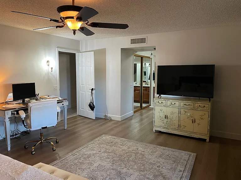Master bedroom has desk and TV