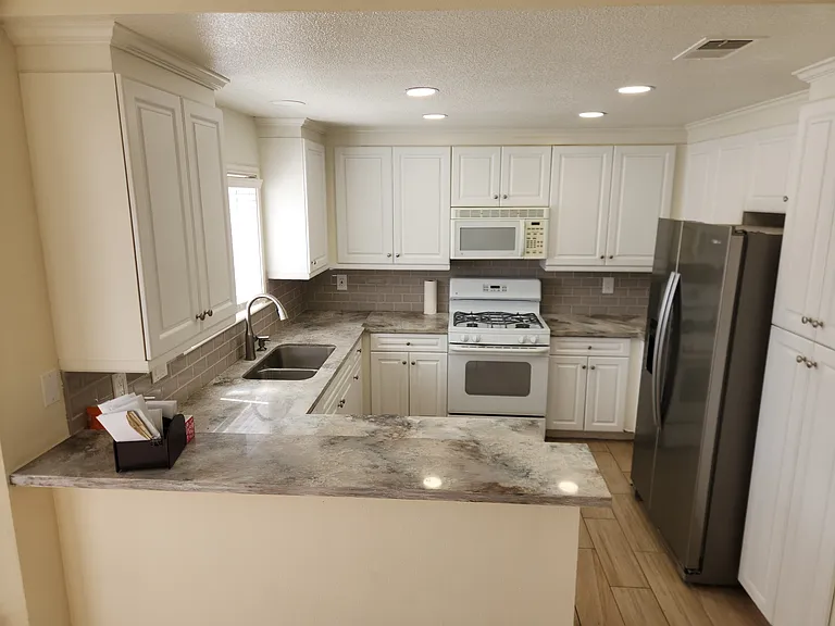 Kitchen with fridge and updated quartz counter top