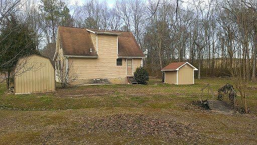 View of back side of house and 2 buildings