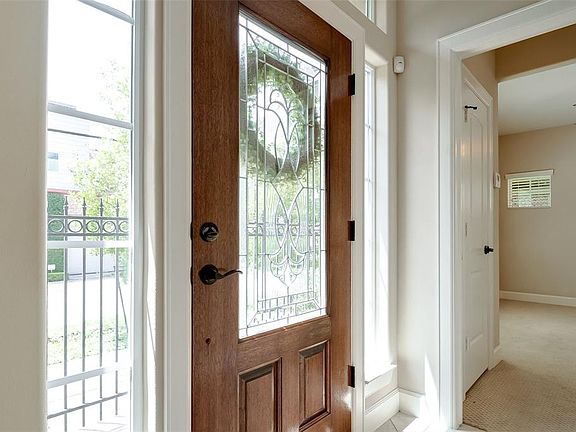Large entryway leading to a downstairs bedroom with ensuite bath, beautiful staircase, garage and large storage closet.