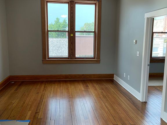 Same room looking north into living space. Restored original front window overlooking city street. Refinished hardwood floors throughout.