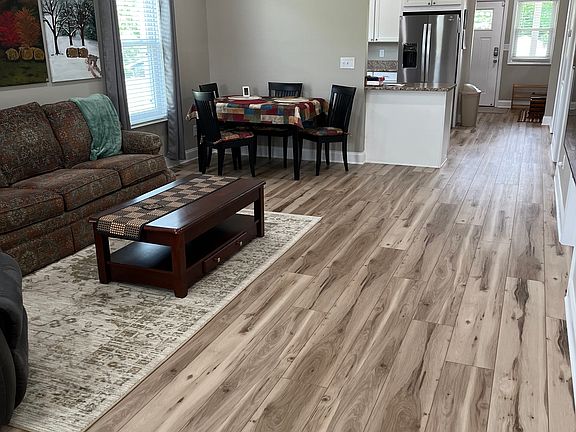 Living/dining area with kitchen and back door shown