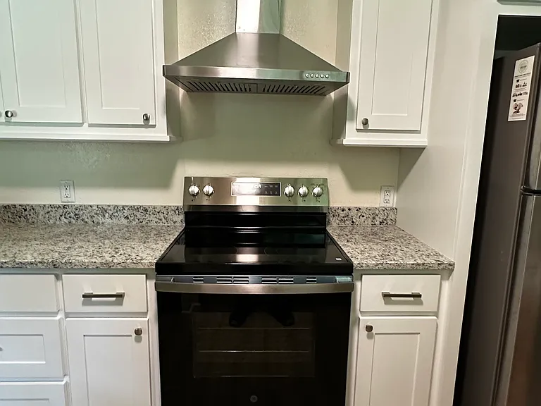 Brand new electric range and vent hood.