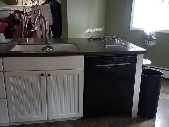 Kitchen island with sink and dishwasher, more storage drawers and seating for 3. 1st floor laundry is accessible from kitchen.