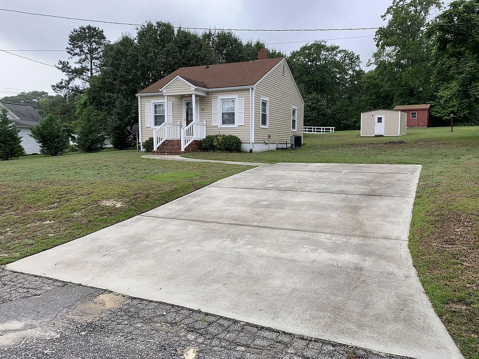 View of front with storage building at rear of lot.