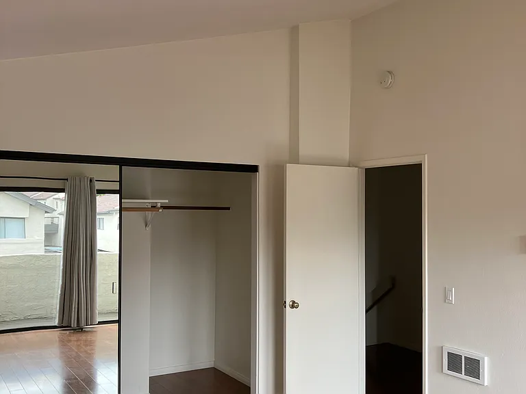 Master bedroom with vaulted ceiling and patio.