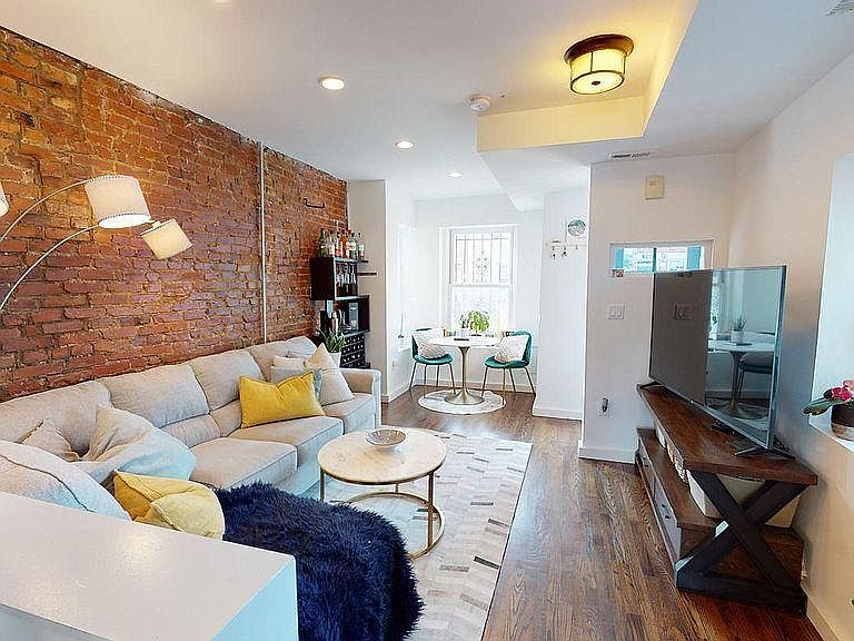 Open-concept living and dining with exposed brick