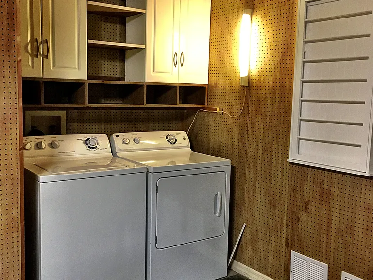 Laundry Room in the two car garage with drying rack.