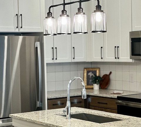 Gourmet kitchens with pendant lighting. Two-tone cabinets with custom tile backsplashes.