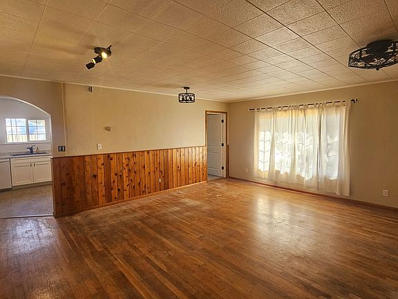 Open Living and Dining Area, kitchen entrance on left, door to bedroom on right