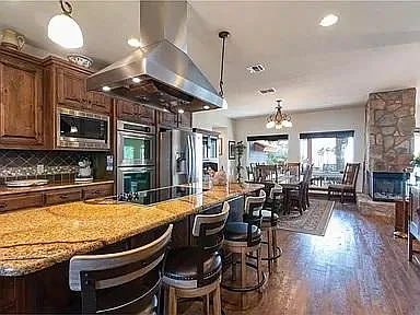 Kitchen opens to dining area, with views and access to the back porch. Wrap-around, wood-burning fireplace makes this a cozy retreat.