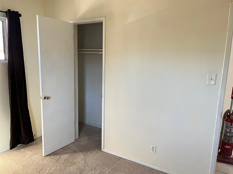 Bedroom w closet door open.