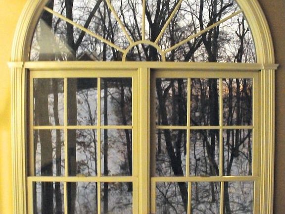 Large window in study looks out to wooded area of property