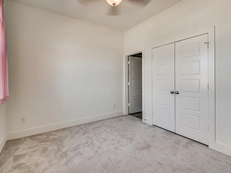 Bedroom #2 with large closet and lots of natural sunlight showing the entrance to the private en suite full bathroom.