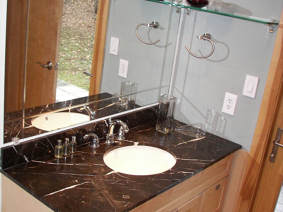 Marble tops, maple cabinets, sleek fixtures give a spa-like feel to the baths.
