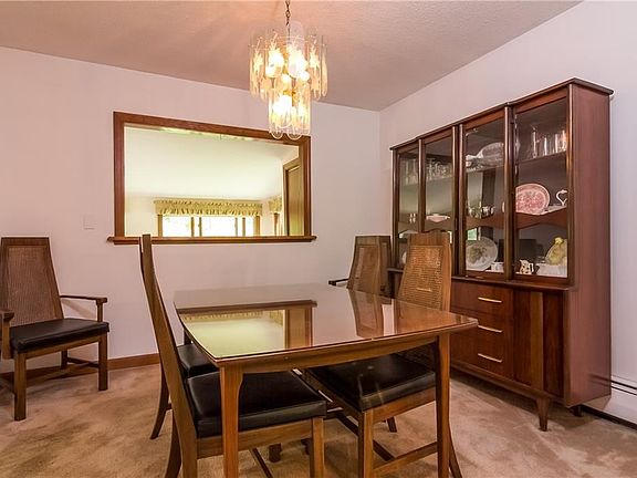 Living room leads to the dining room, open "window" looks into the 4-season sunroom.