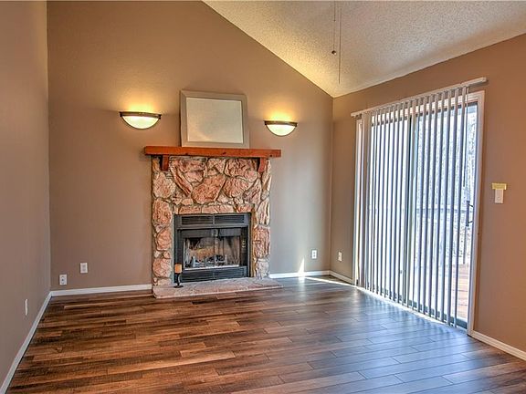 The main living area holds a wood fireplace and has easy access to the deck.