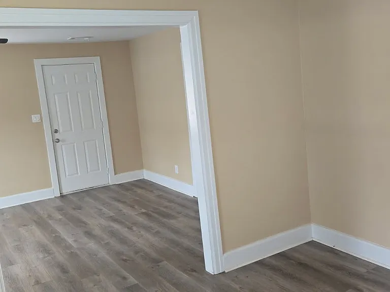 Sun-filled room with neutral tones and cozy carpeting, offering a warm and inviting space that's easy to personalize.