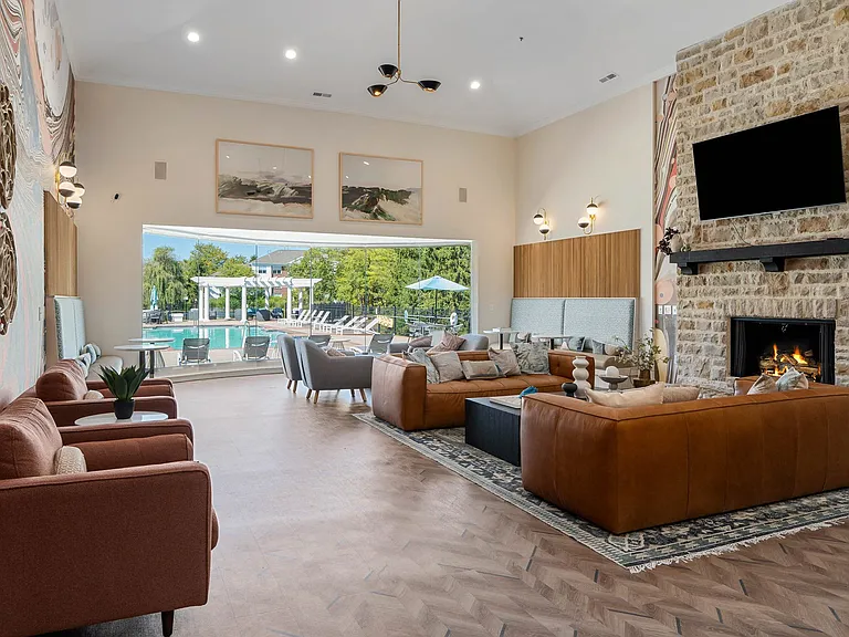 Clubroom with cozy seating, fireplace and television.