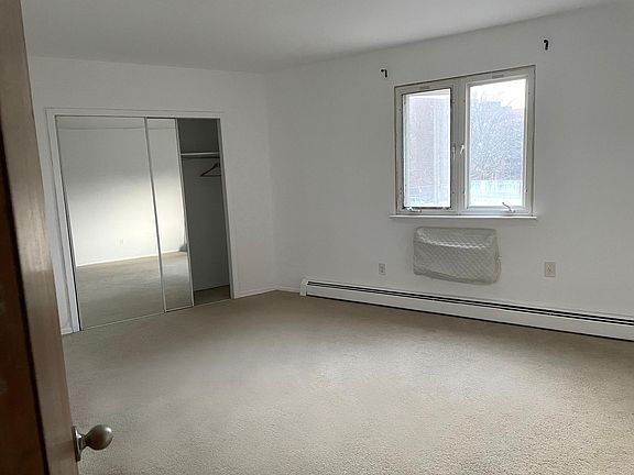 Large master bedroom with full size mirrored closet and small private bathroom