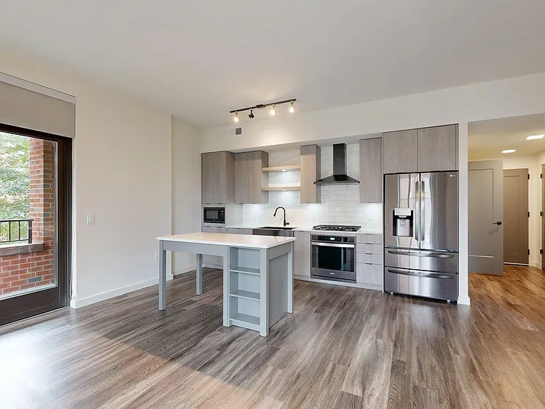 Apartment Kitchen with Quartz counter tops and Wood Style Flooring.