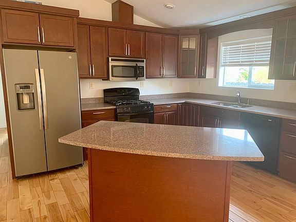 Fully equipped kitchen with gas stove top, fridge, and dishwasher