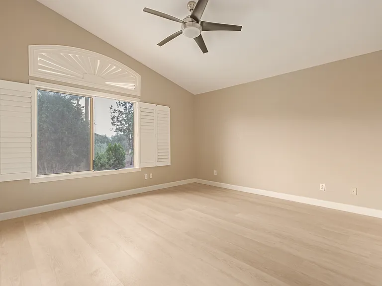 Upstairs Bedroom with Large Windows Overlooking the Backyard and Community Trees.