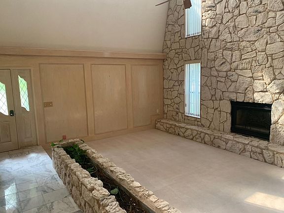 Fantastic Living Room with 27 foot ceiling, built-in cabinets and shelves, marble entry and fireplace.