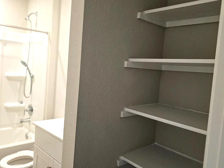 Full secondary bathroom with convenient built-in shelving for added storage and organization.