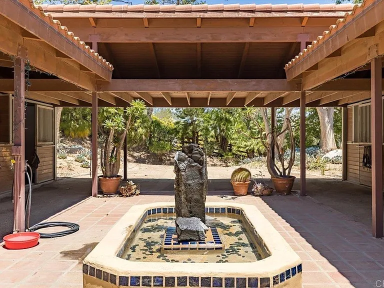 Horse stables have a courtyard and four box stalls on each side.