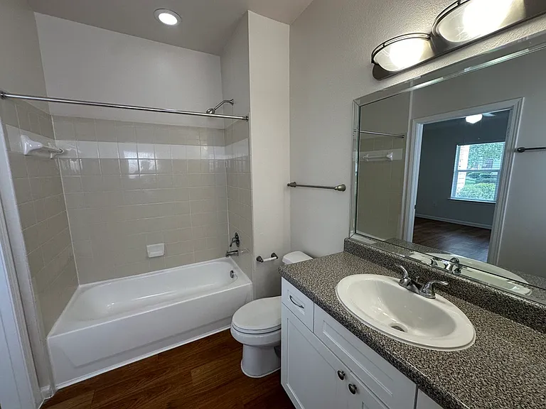 Elegant bathroom with a modern vanity, sleek countertop, and a relaxing bathtub featuring natural light from a nearby window. Elegant bathroom with a modern vanity, sleek countertop, and a relaxing bathtub featuring natural light from a nearby window.