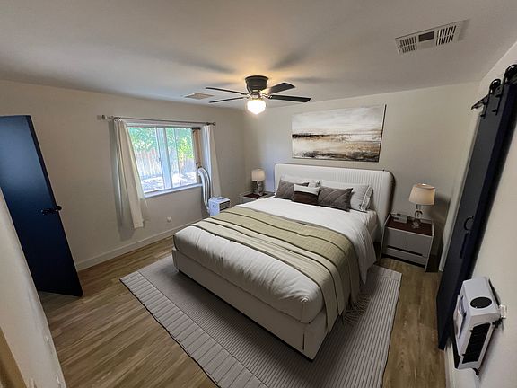 Master bedroom with on-suite bathroom, walk-in closet, sliding barn door, and a/c unit.
