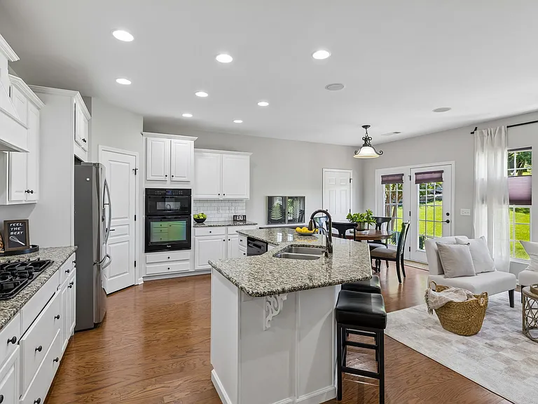 The kitchen, breakfast area, and keeping room are perfectly positioned to capture beautiful views of the private backyard, creating a bright and inviting space that feels connected to the outdoors year-round.