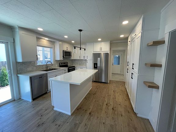 Huge Modern Kitchen with marble backsplash, stainless appliances and solid quartz counters. Huge island