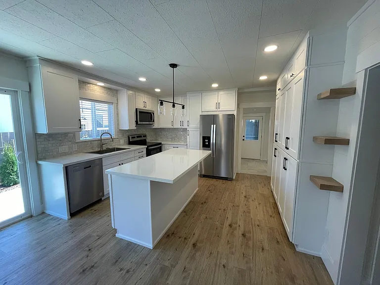Huge Modern Kitchen with marble backsplash, stainless appliances and solid quartz counters. Huge island