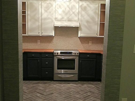 Beautifully upgraded kitchen with butcher block counters and stainless appliances