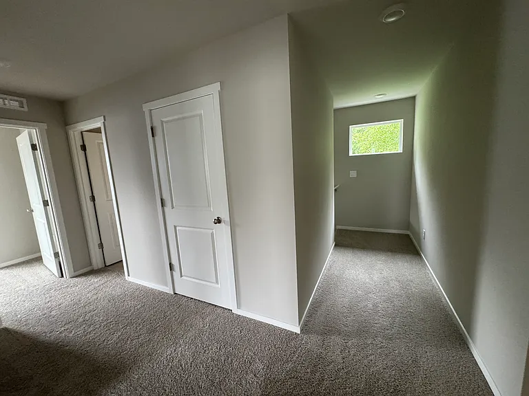 View in hallway looking at stair case. The doors on the left are a closet, the bathroom entry, and 4th bedroom/ bonus room entry.